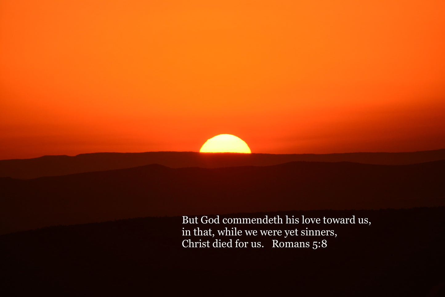 Sunset over a mountain range with a biblical quote on a black background