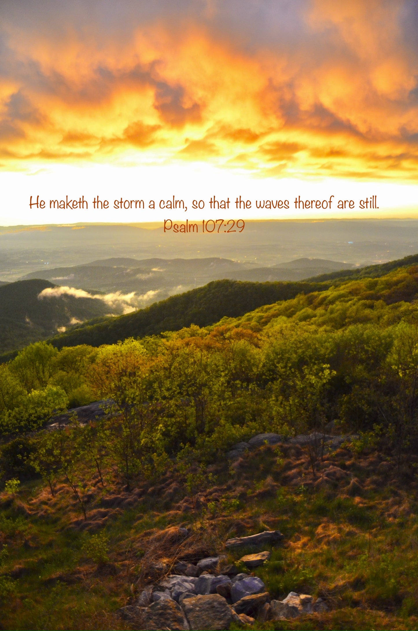 Scenic view of mountains with a sunset sky and a Bible verse quote.